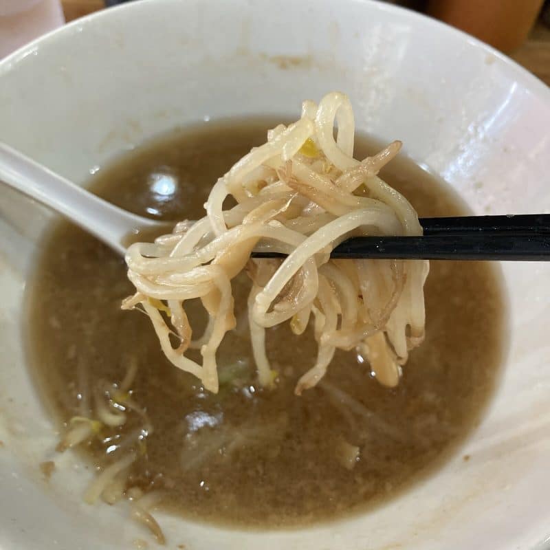食べ進めた豚レンジャーのラーメン ミニの丼 残ったモヤシを箸ですくう