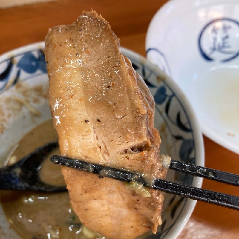 【自家製麺 福は内】のチャーシューをつけ汁に浸す