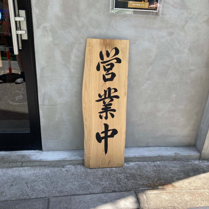 中野坂上【らぁめん 希いろ】の店先に立つ木の「営業中」の札