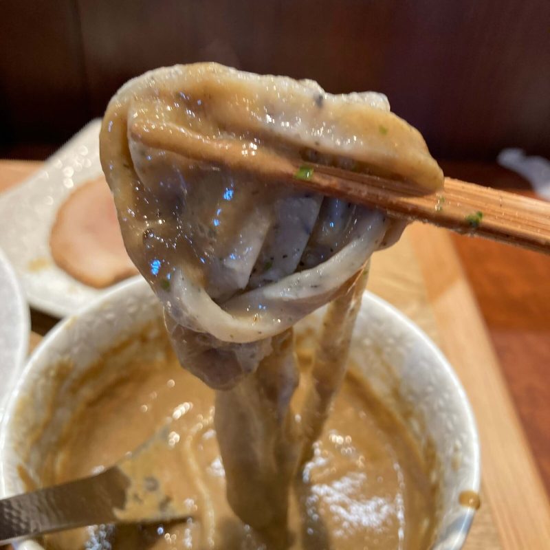 与野【御影麺 鏑矢】のつけ汁が絡んだ麺を箸で持ち上げる