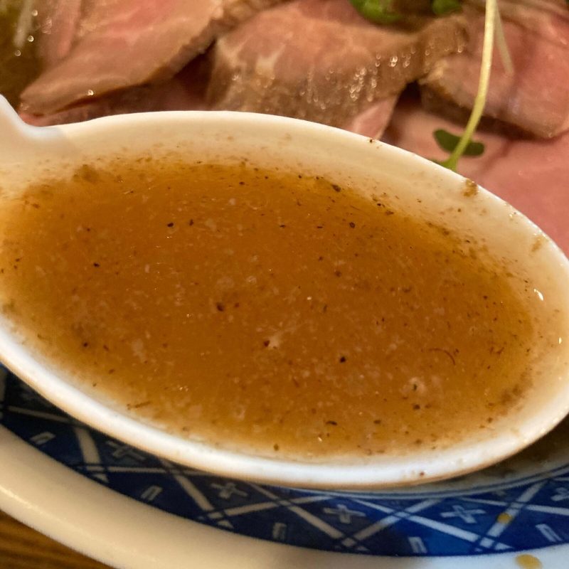 東十条【燦燦斗】の豚骨魚介スープをレンゲでひと掬い